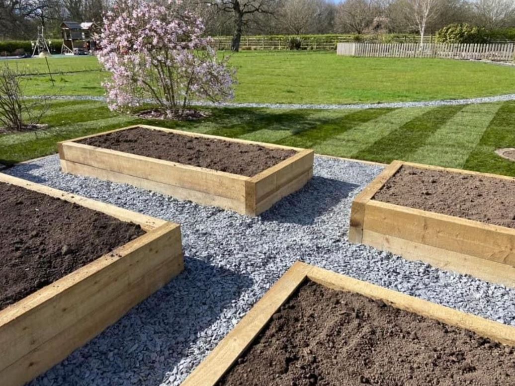 Landscaping to a commercial communal space — fresh turf shaped around paving and mature planting.